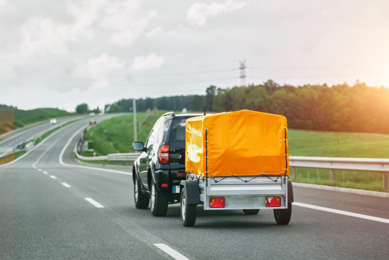 SUV and Rental Cargo Trailer on a Road. Efficient moving.